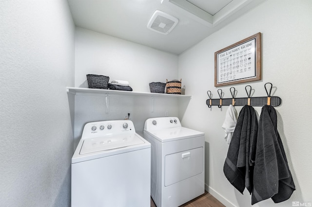 laundry area featuring laundry area, wood finished floors, and washing machine and dryer