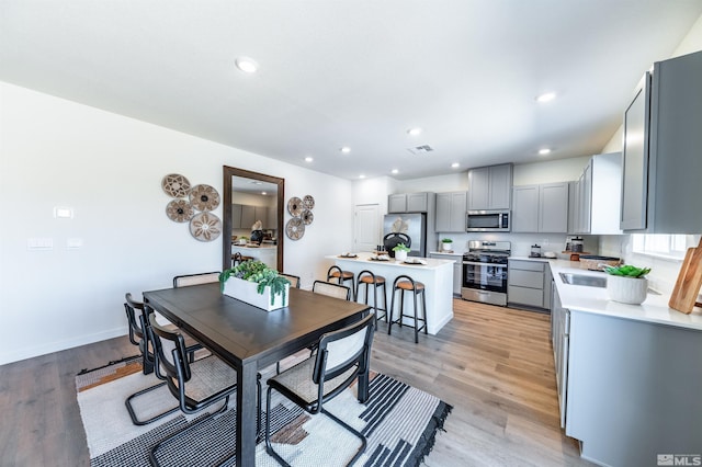 dining space with visible vents, baseboards, light wood-type flooring, and recessed lighting