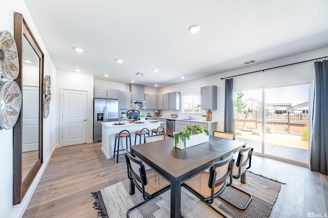 dining room featuring light wood-style flooring, visible vents, and recessed lighting
