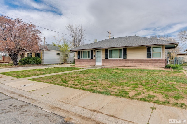 single story home with brick siding, a front yard, and a shingled roof