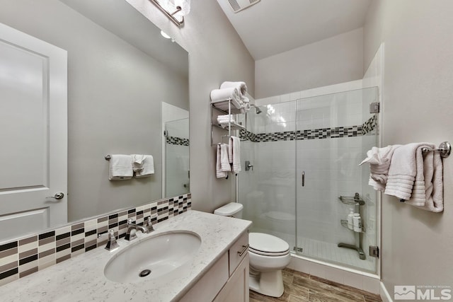 full bathroom with visible vents, toilet, a shower stall, vanity, and wood finished floors