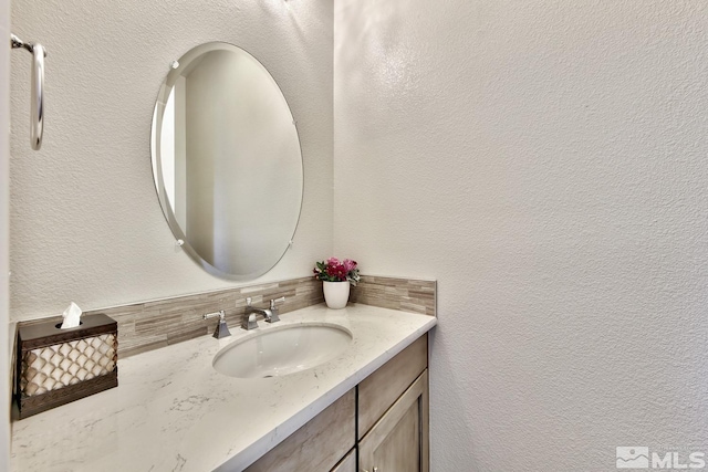 bathroom featuring tasteful backsplash and vanity