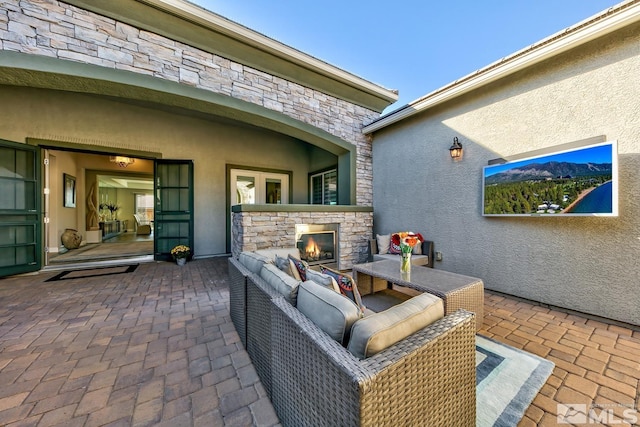 view of patio with an outdoor living space with a fireplace