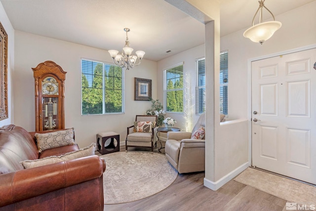 entryway featuring a chandelier, light wood-style floors, baseboards, and visible vents