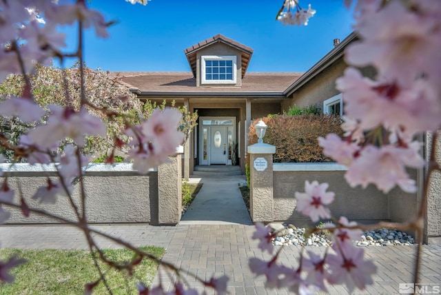 entrance to property with stucco siding and fence