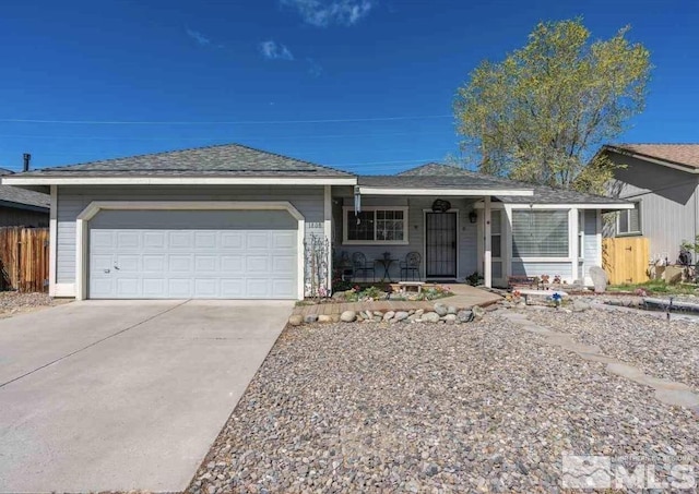 ranch-style house featuring an attached garage, fence, and driveway