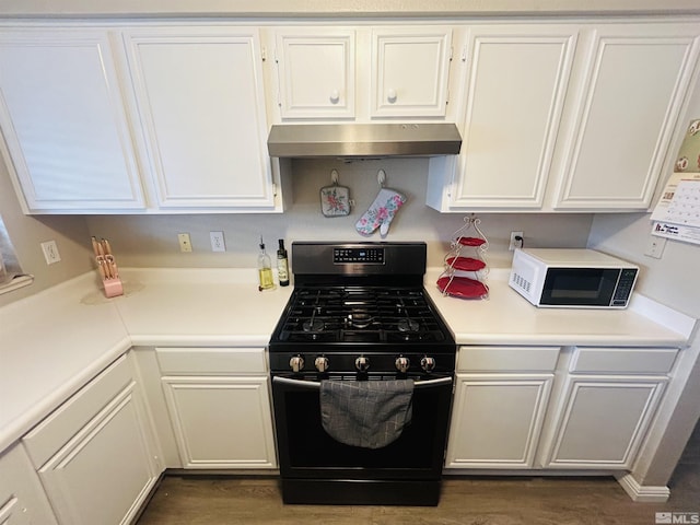 kitchen with black gas stove, white microwave, light countertops, white cabinets, and under cabinet range hood