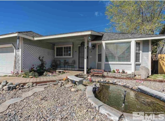 ranch-style house featuring an attached garage and a shingled roof