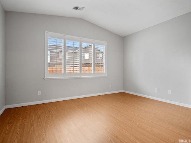 unfurnished room featuring lofted ceiling, visible vents, baseboards, and light wood-style flooring