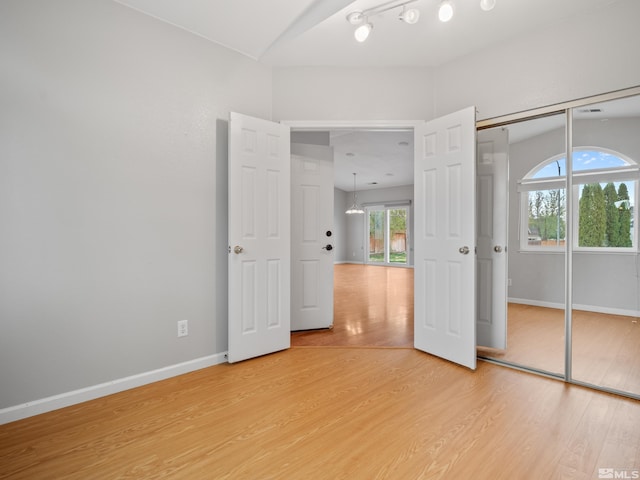unfurnished bedroom with a closet, light wood-type flooring, and baseboards
