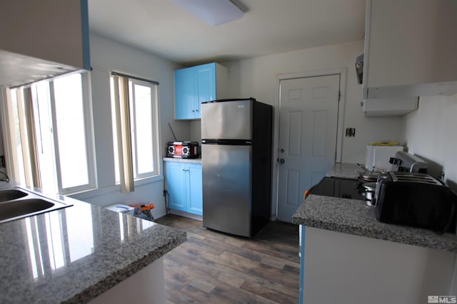 kitchen featuring a sink, light wood-type flooring, and freestanding refrigerator