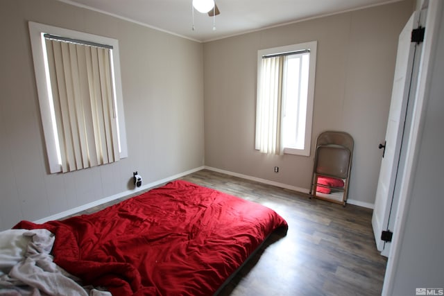 bedroom featuring baseboards, ornamental molding, and wood finished floors