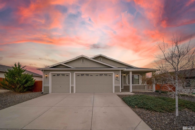 view of front of home with an attached garage, concrete driveway, and covered porch