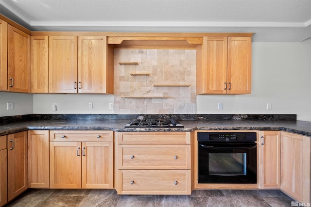 kitchen with dark countertops, backsplash, light brown cabinets, gas stovetop, and black oven