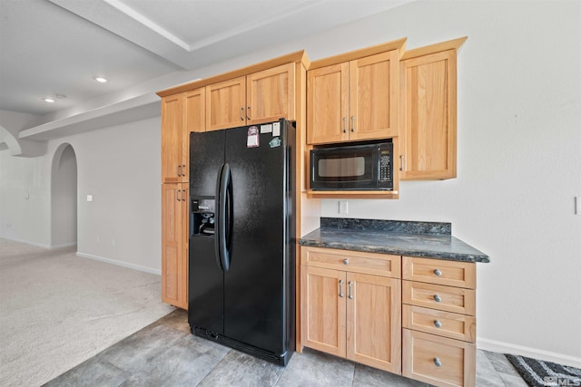 kitchen with arched walkways, light brown cabinets, and black appliances