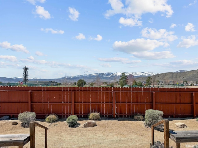 view of yard featuring fence and a mountain view