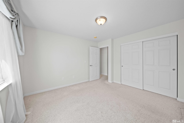 unfurnished bedroom featuring baseboards, a closet, and carpet flooring