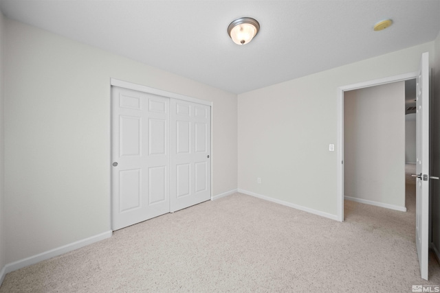 unfurnished bedroom with carpet, a closet, and baseboards