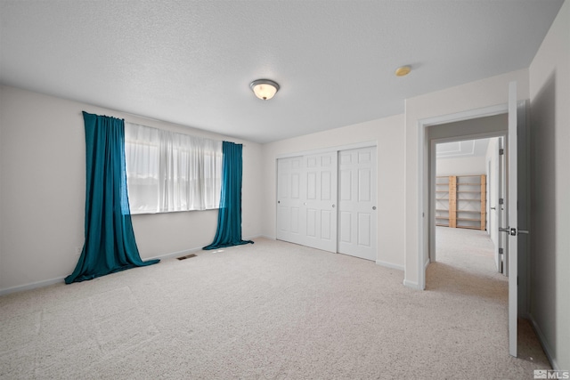 unfurnished bedroom with baseboards, visible vents, and carpet flooring