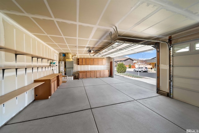 garage with gas water heater, a garage door opener, and heating unit