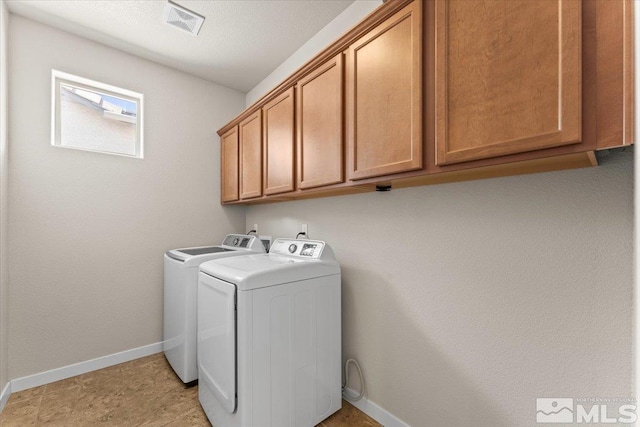 laundry area with baseboards, cabinet space, visible vents, and independent washer and dryer