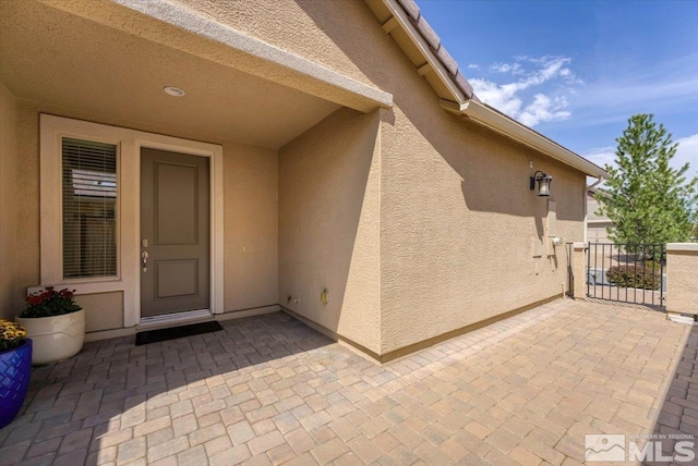 doorway to property with a patio and stucco siding