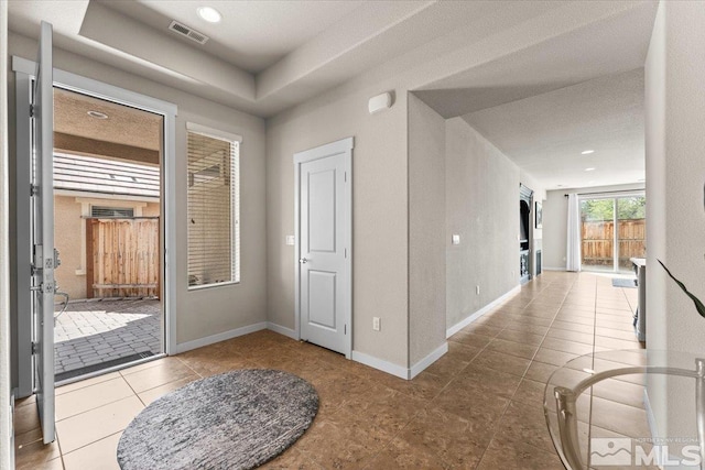 foyer with baseboards, tile patterned flooring, and visible vents