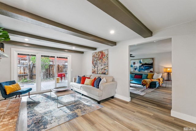 living room featuring wood finished floors, baseboards, beam ceiling, and ceiling fan