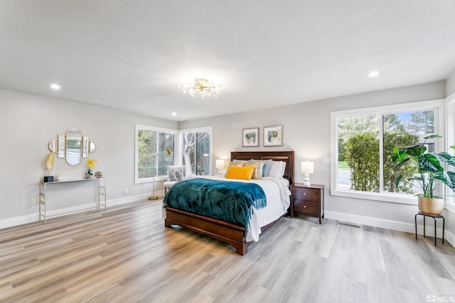 bedroom featuring baseboards, light wood-style floors, and recessed lighting