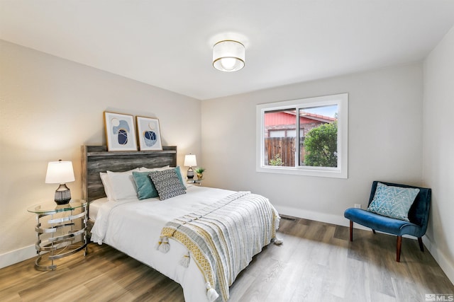 bedroom with baseboards and wood finished floors