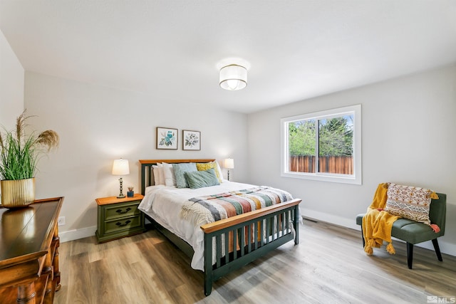 bedroom with wood finished floors and baseboards