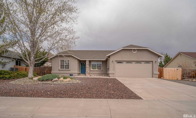 single story home featuring fence, central air condition unit, concrete driveway, stucco siding, and a garage