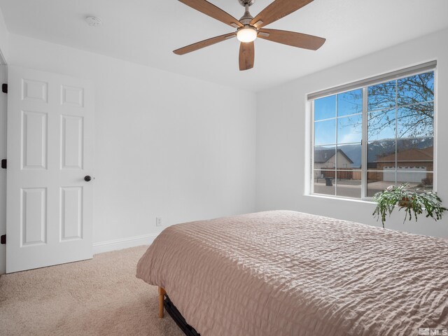 carpeted bedroom with ceiling fan and baseboards