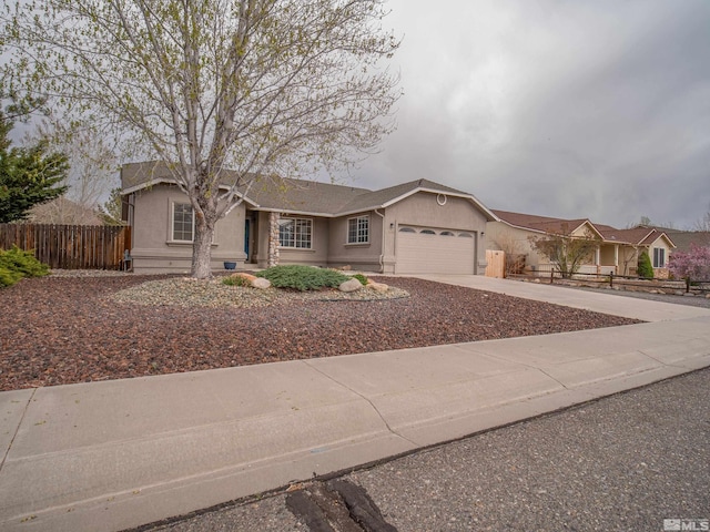 ranch-style home with stucco siding, fence, driveway, and a garage