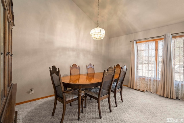 dining space featuring vaulted ceiling, baseboards, light carpet, and an inviting chandelier