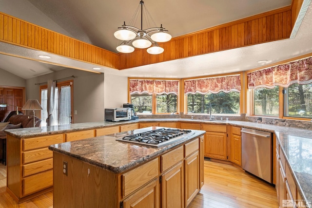 kitchen featuring plenty of natural light, vaulted ceiling, a sink, and appliances with stainless steel finishes