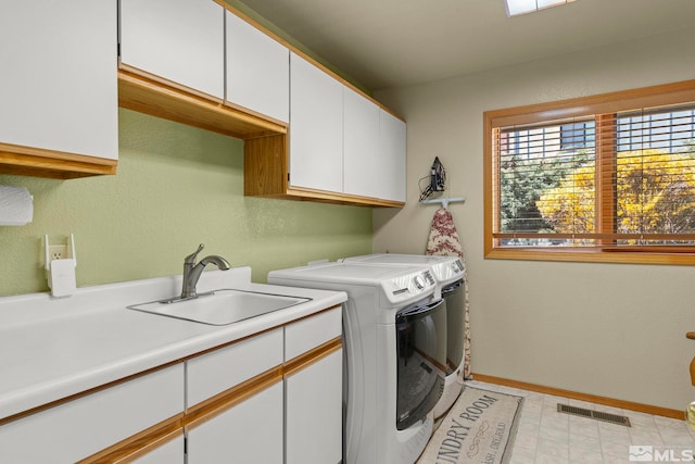 laundry area featuring visible vents, a sink, washing machine and dryer, baseboards, and cabinet space