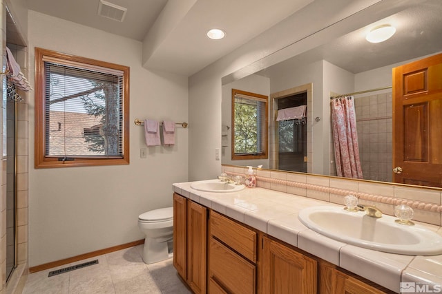 bathroom featuring baseboards, a sink, and visible vents