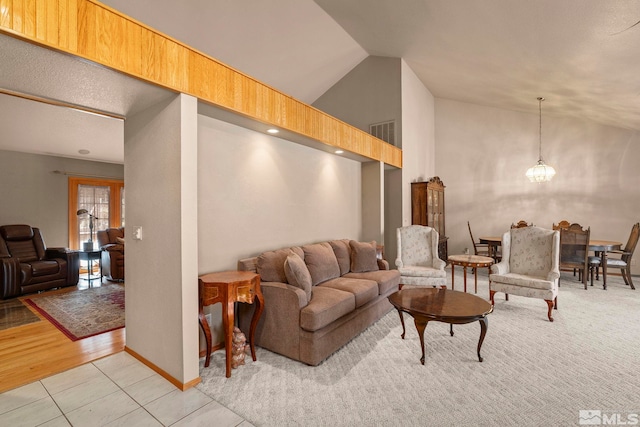 living area with lofted ceiling, light tile patterned flooring, and an inviting chandelier