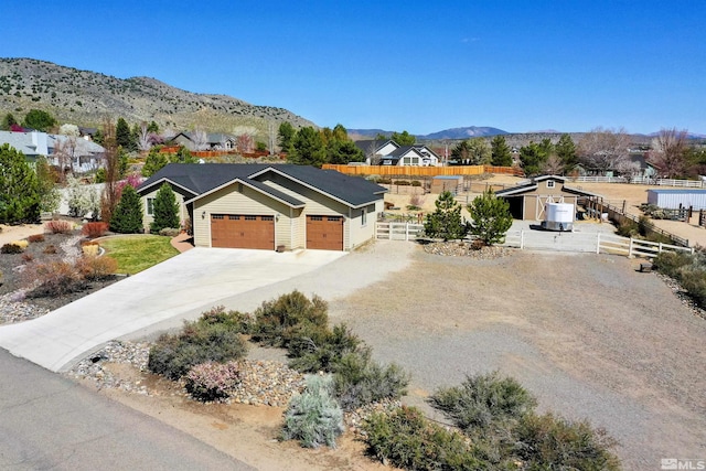 ranch-style home with concrete driveway, an attached garage, fence, and a residential view