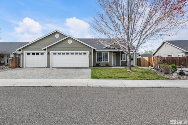 ranch-style home with fence, an attached garage, driveway, and a front yard