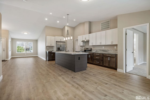 kitchen featuring high vaulted ceiling, a sink, stainless steel appliances, under cabinet range hood, and visible vents