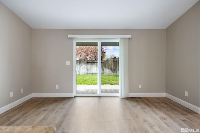 unfurnished room with baseboards and light wood finished floors