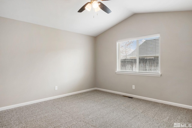 carpeted empty room with ceiling fan, lofted ceiling, visible vents, and baseboards