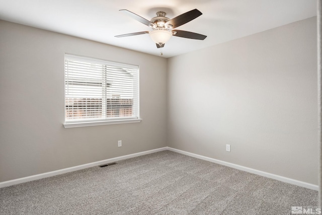spare room with baseboards, a ceiling fan, visible vents, and carpet flooring