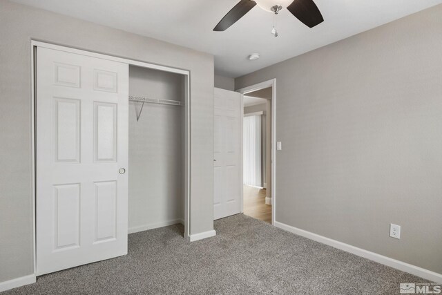 unfurnished bedroom with carpet, a closet, baseboards, and ceiling fan