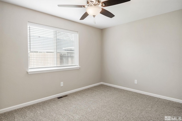 carpeted empty room featuring baseboards, a ceiling fan, and visible vents