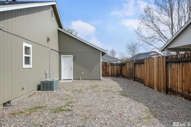 back of house featuring central AC and fence