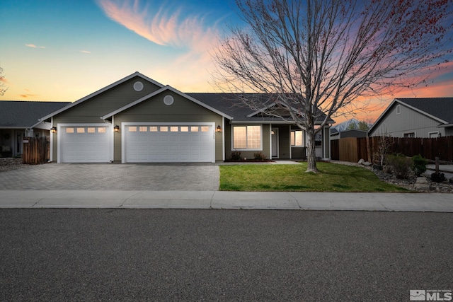 ranch-style house featuring an attached garage, a front lawn, fence, and driveway
