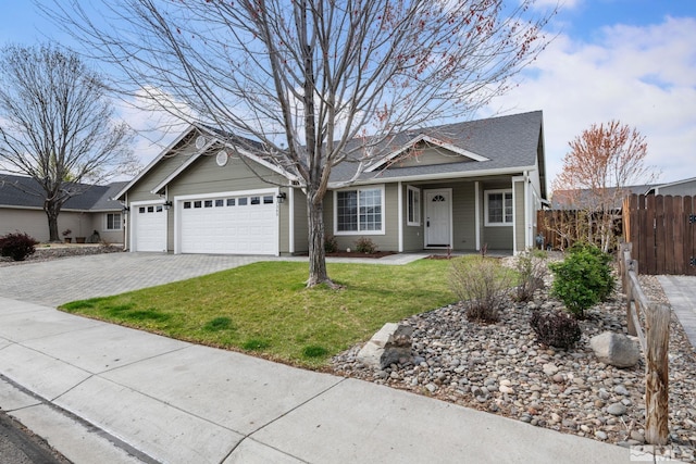 view of front of home featuring fence, an attached garage, a front yard, and decorative driveway